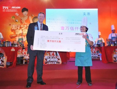 沃爾瑪中國大賣場采購部非食品采購副總裁施德威（左）為沃爾瑪廚藝達人爭霸賽全國決賽冠軍（右）頒發15000元現金大獎